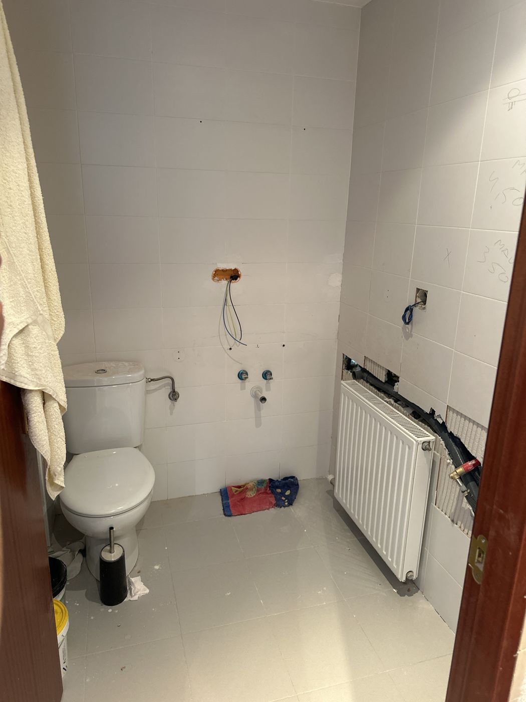 Baño en obra, con la fontanería y el cableado a la vista