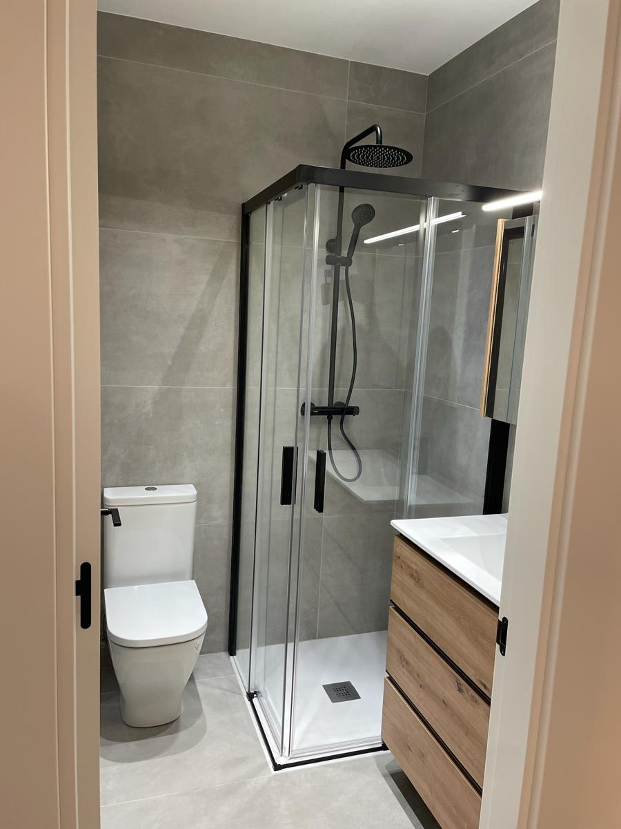Baño con mampara y grifería negras