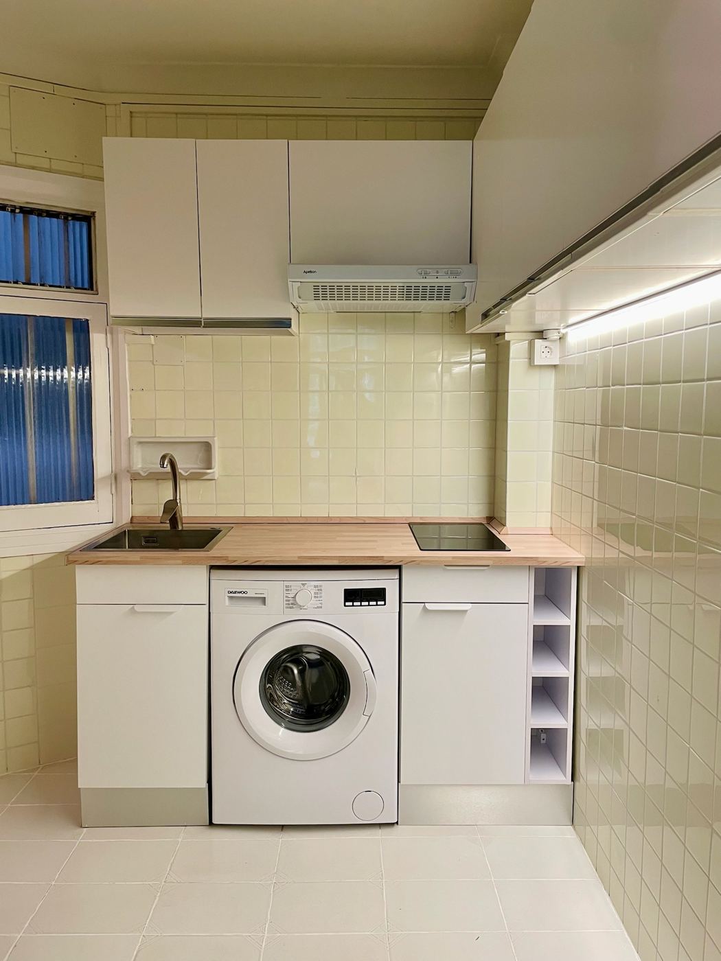 Cocina terminada con muebles blancos y encimera de madera