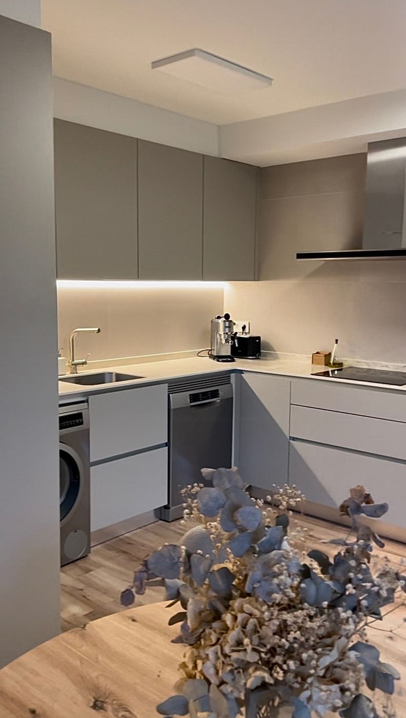 Cocina terminada en gris con luz bajo los muebles
