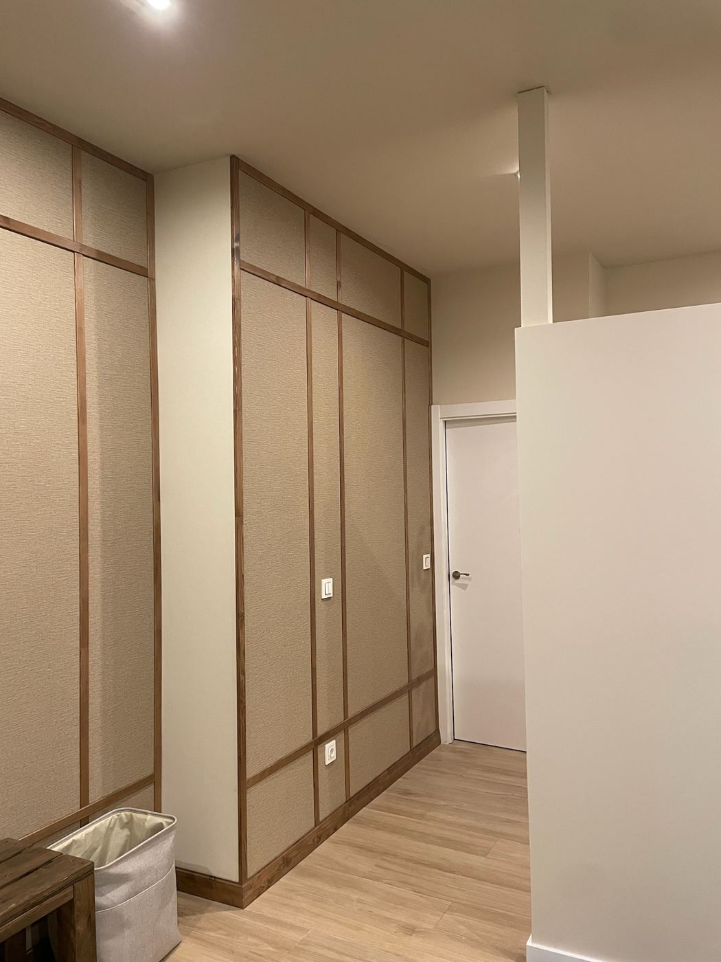 Pared terminada con paneles de tela y listones de madera